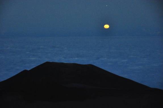 Depois do sol se pôr, nasce uma lua cheia, amarela e incrível, no topo do Mauna Kea, na Big island, no Hawaii
